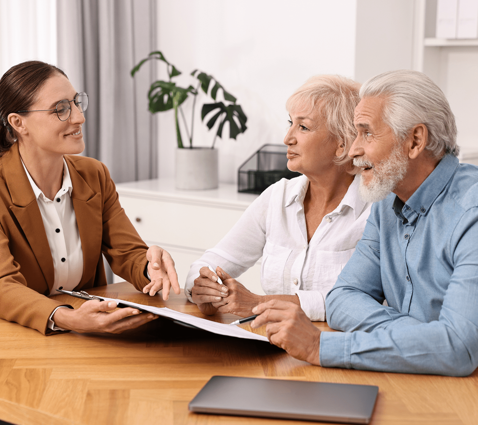 Professional meeting between advisor and older couple.