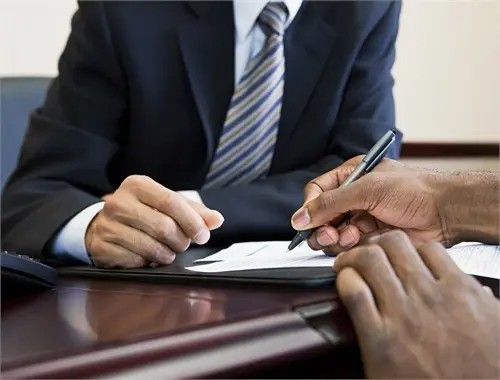Hands signing a contract at desk