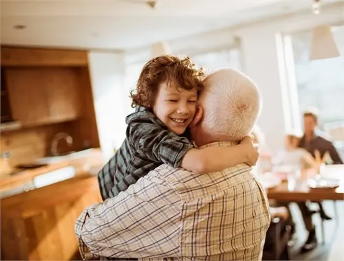 Child hugging grandparent in cozy kitchen