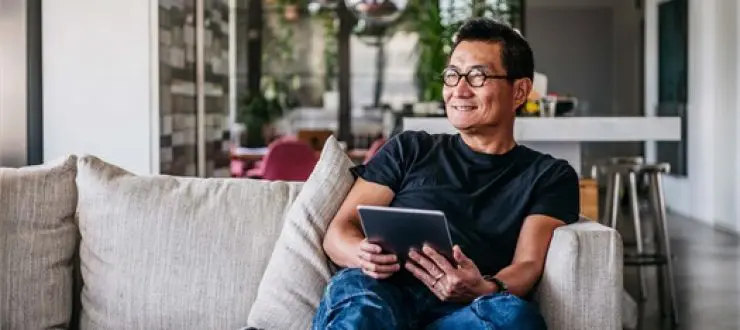 Smiling man holding tablet indoors