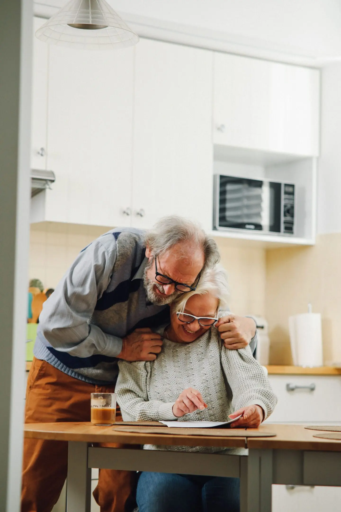 Seniors reading together in the kitchen
