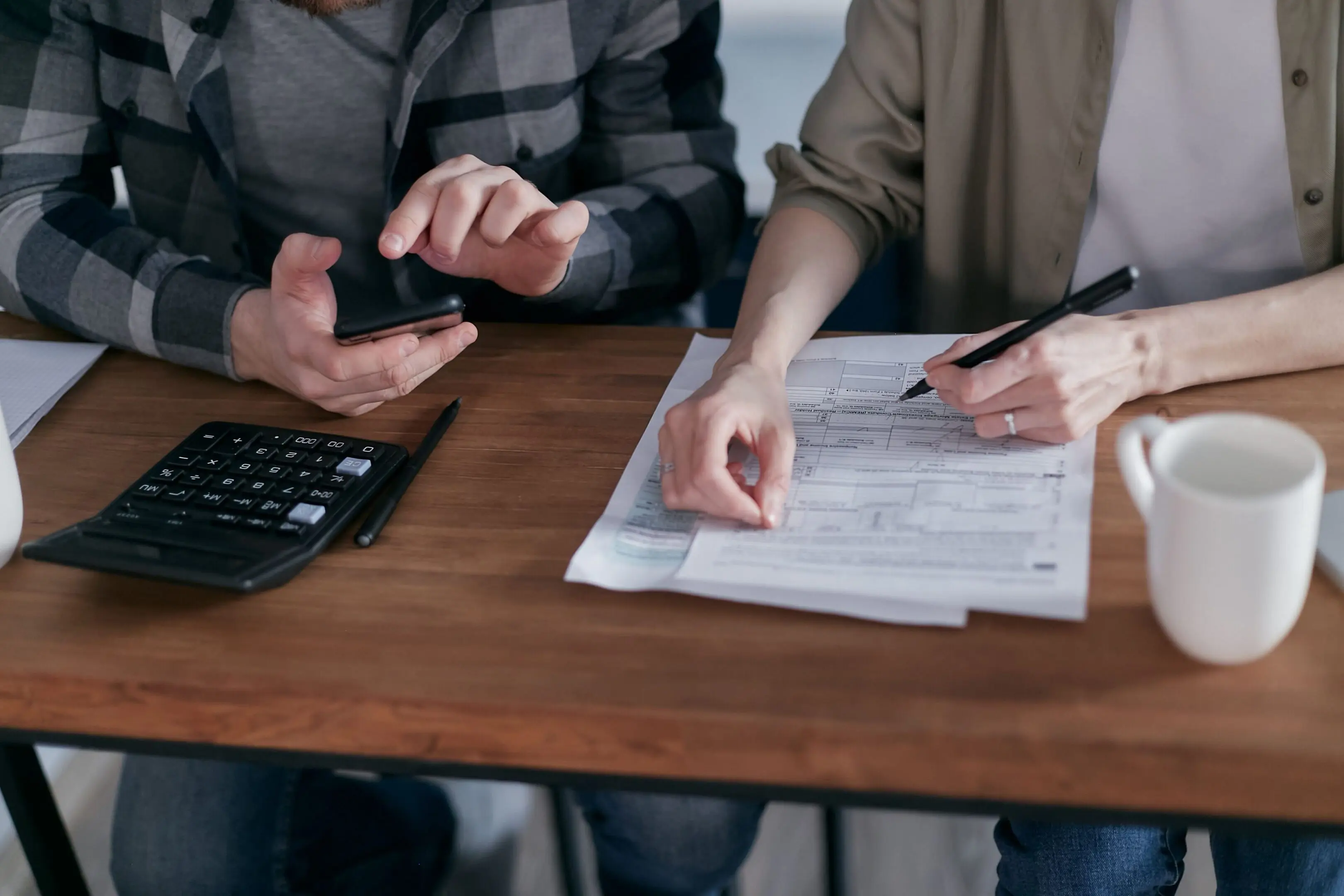 People reviewing documents and using a calculator